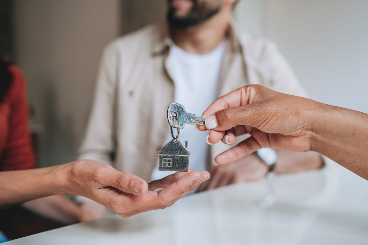 Smiling couple receiving keys from a real estate agent inside an empty apartment, celebrating the purchase or rental of their new home. Concept of real estate success, moving in, and new beginnings