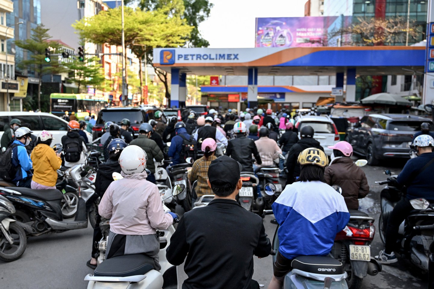 Motorists queue to pump gasoline into their vehicle at a gas station in Hanoi on March 10, 2026. Vietnam announced on March 9 it was scrapping tariffs on fuel imports, as the US-Israeli war with Iran disrupts oil supplies and pushes prices to their highest level since 2022. (Photo by Nhac NGUYEN / AFP via Getty Images)