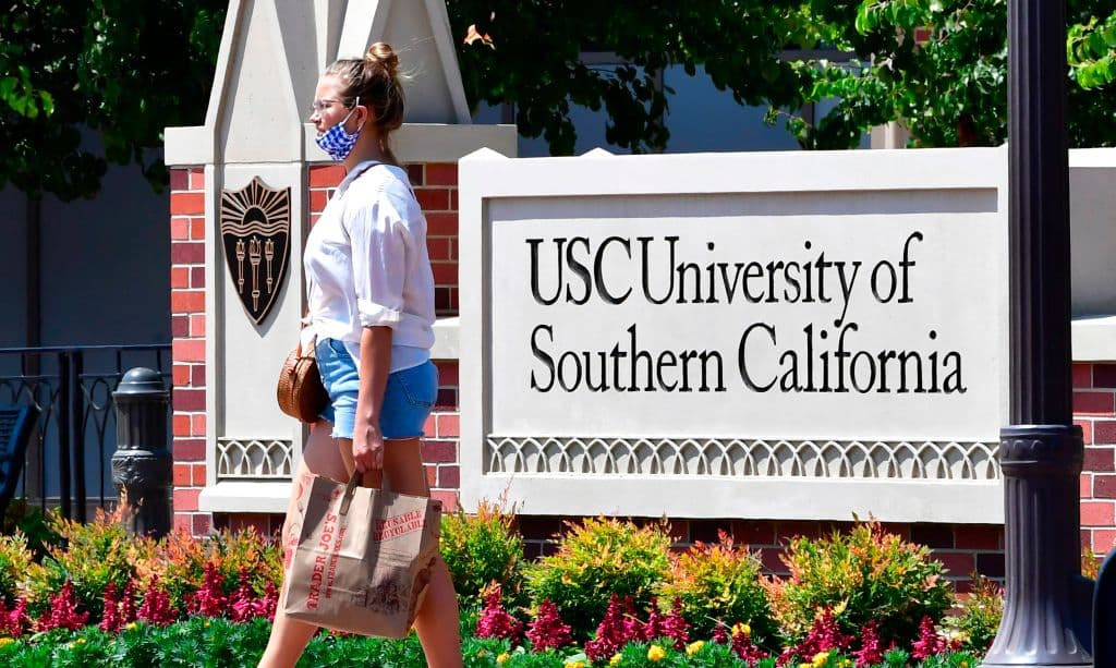 A woman walks past a sign at the University of Southern California (USC) in Los Angeles, as seen in August 2020. (Photo by Frederic J. Brown—AFP/Getty Images)