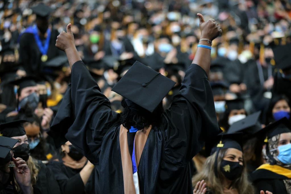 A graduating Army veteran, center, is recognized for her service during the 53rd Commencements of the University of Massachusetts Boston at TD Garden in Boston, as seen in August 2021. (Photo by Craig F. Walker—The Boston Globe/Getty Images)