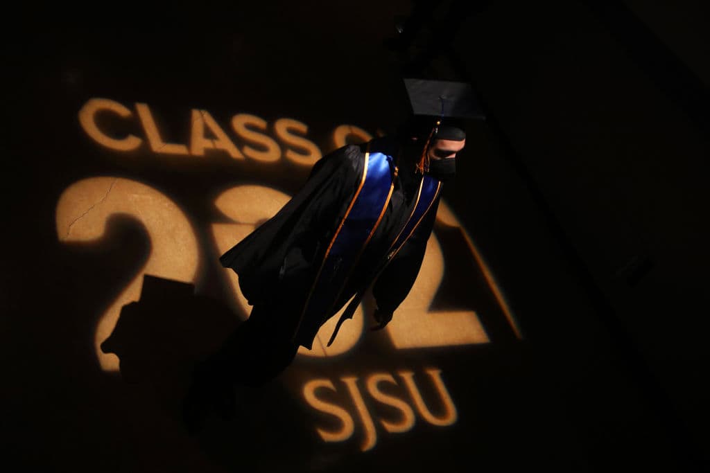 A San Jose State University graduate walks across a floor display before the start of commencement ceremonies, as seen in December 2021. (Aric Crabb—MediaNews Group/East Bay Times/Getty Images)