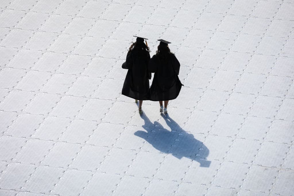 Students walk across the field of Fenway Park as they arrive to the Northeastern University Commencement in Boston, as seen in May 2022. (Photo by Erin Clark—The Boston Globe/Getty Images)