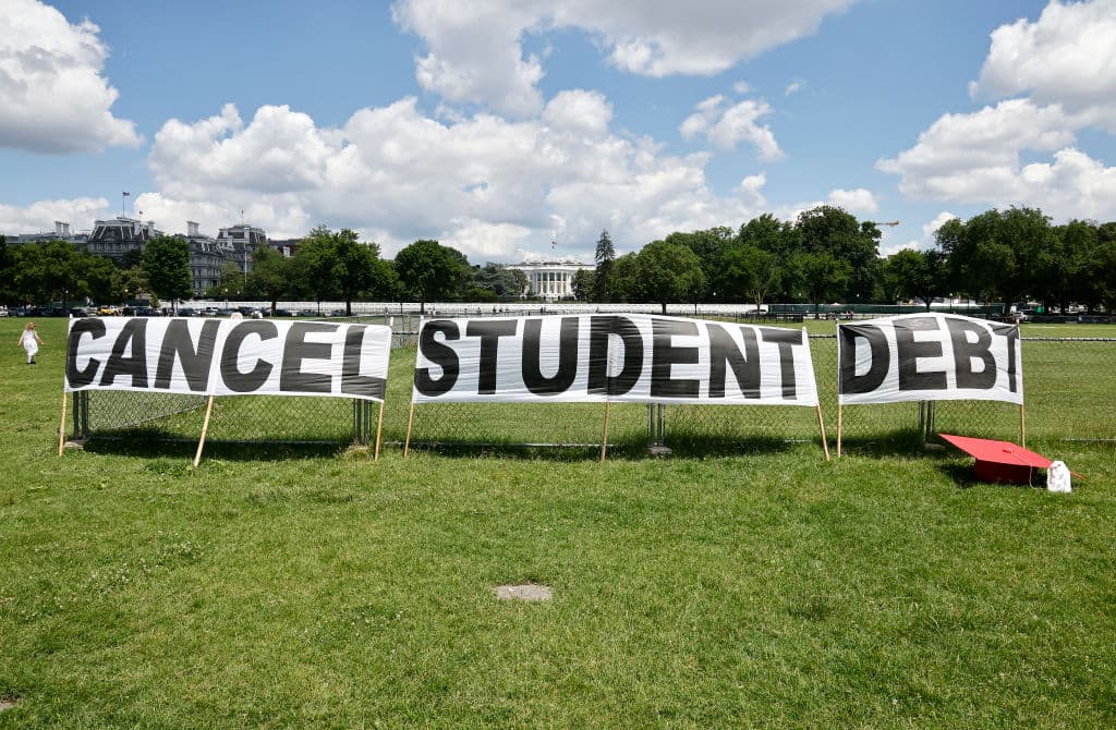 Advocates display a hand-painted sign on the Ellipse in front of The White House to call on President Joe Biden to sign an executive order to cancel student debt, as seen in June 2021. (Photo by Paul Morigi/Getty Images for We The 45 Million)