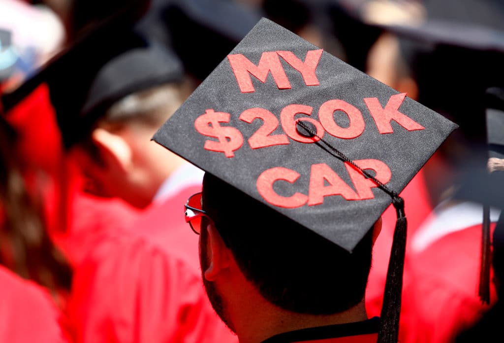 A graduate wears the cost of tuition on his cap during the Boston University Commencement, as seen in May 2017. (Photo by Jessica Rinaldi—The Boston Globe/Getty Images)