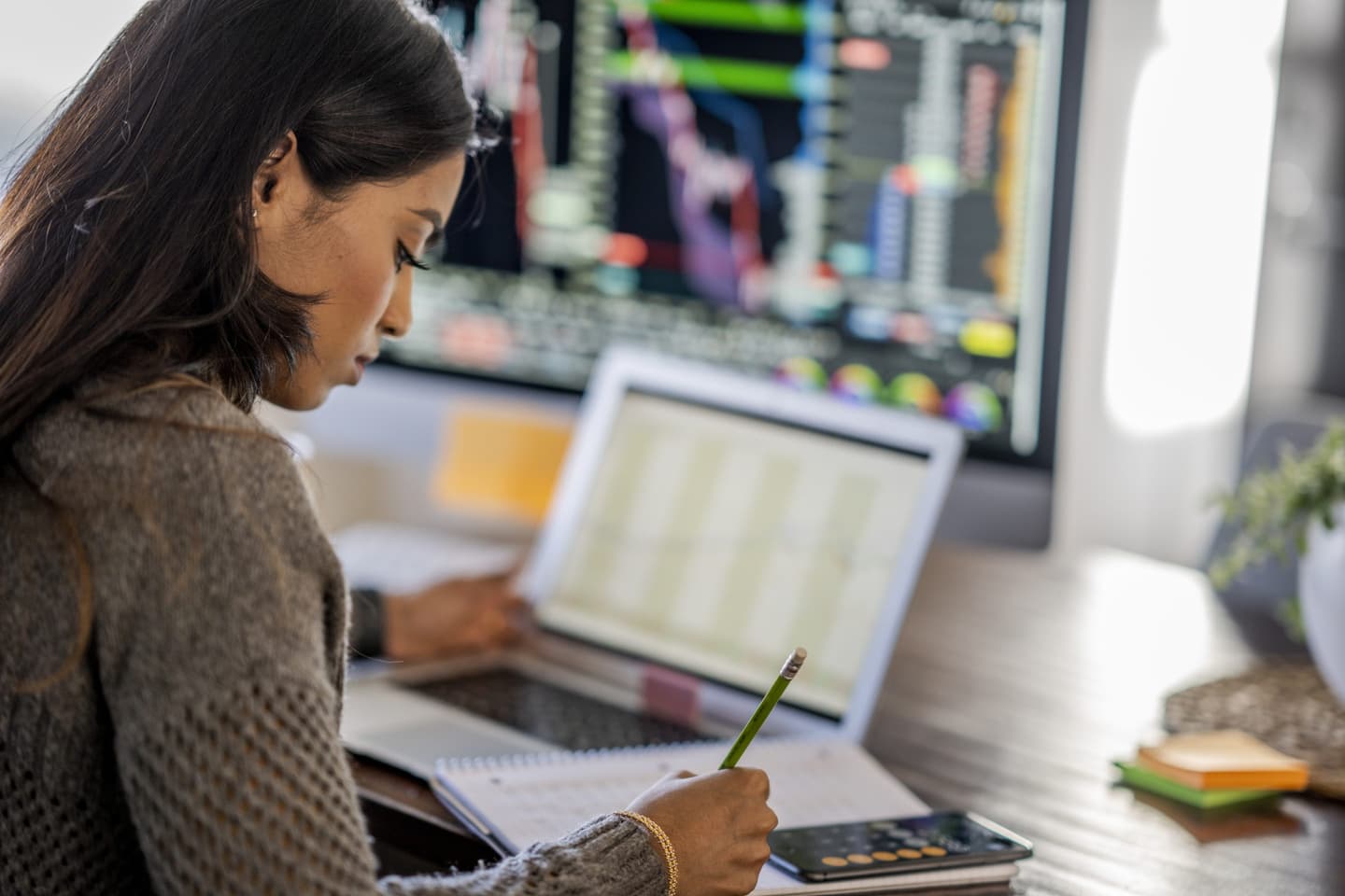 Young business woman takes notes from her laptop