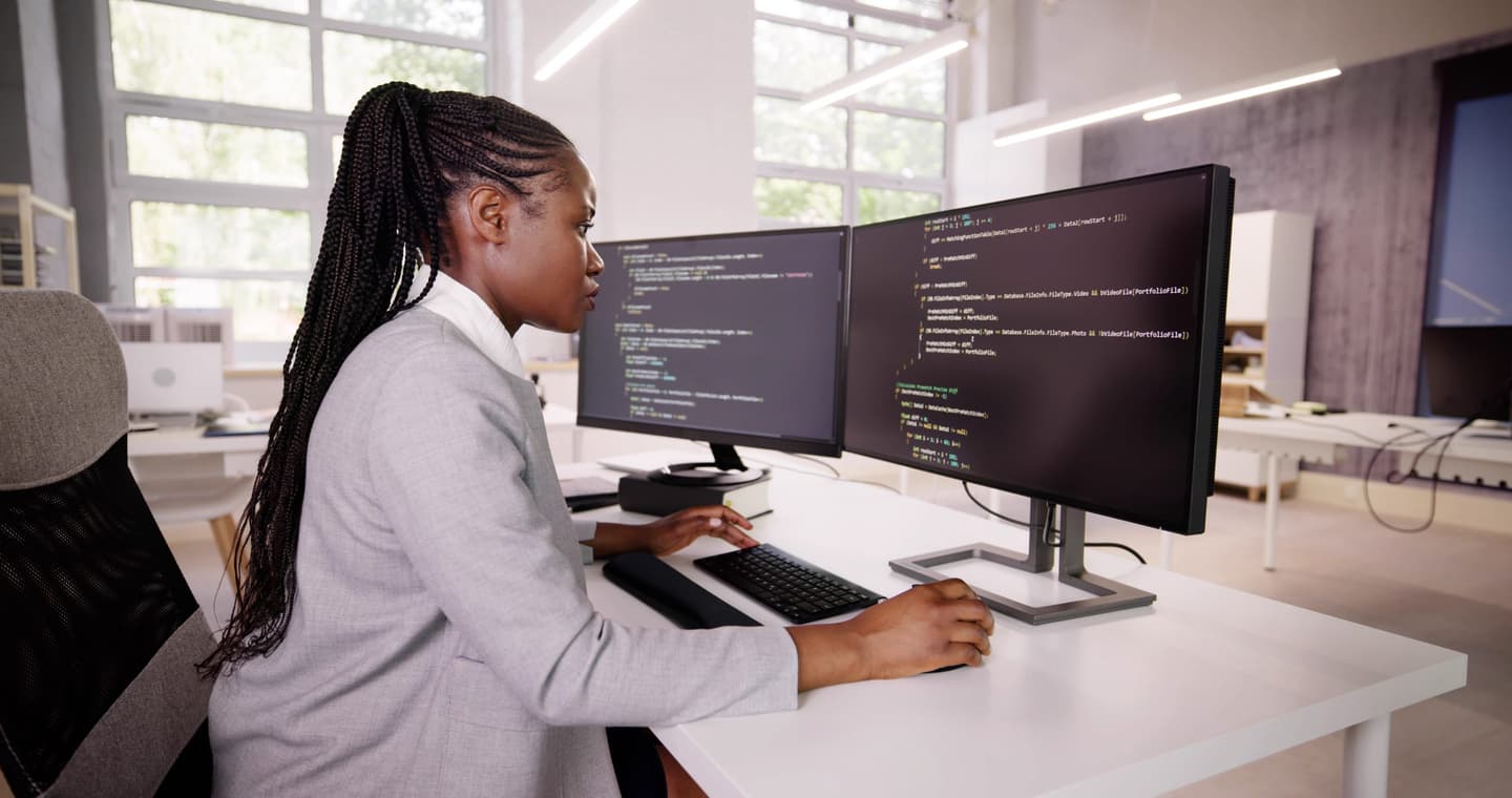 African American Coder Using Computer At Desk