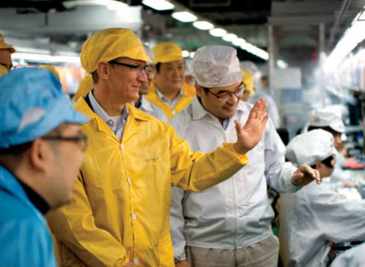 Cook, in yellow, visits a Foxconn facility in Henan Province, China, where iPhones are produced.