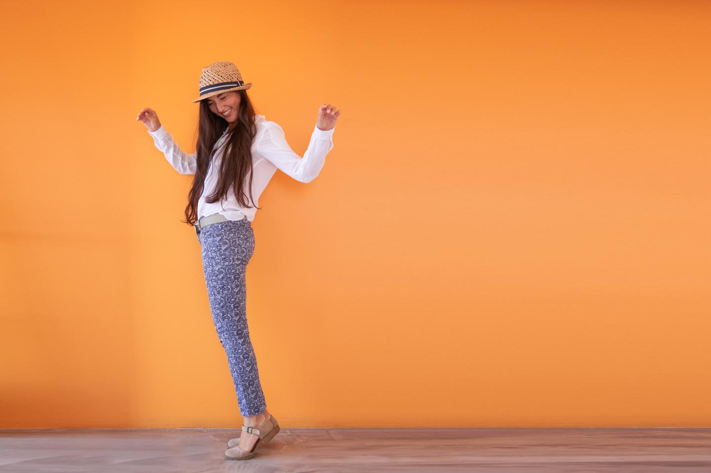 Asian woman smiling in front of orange wall