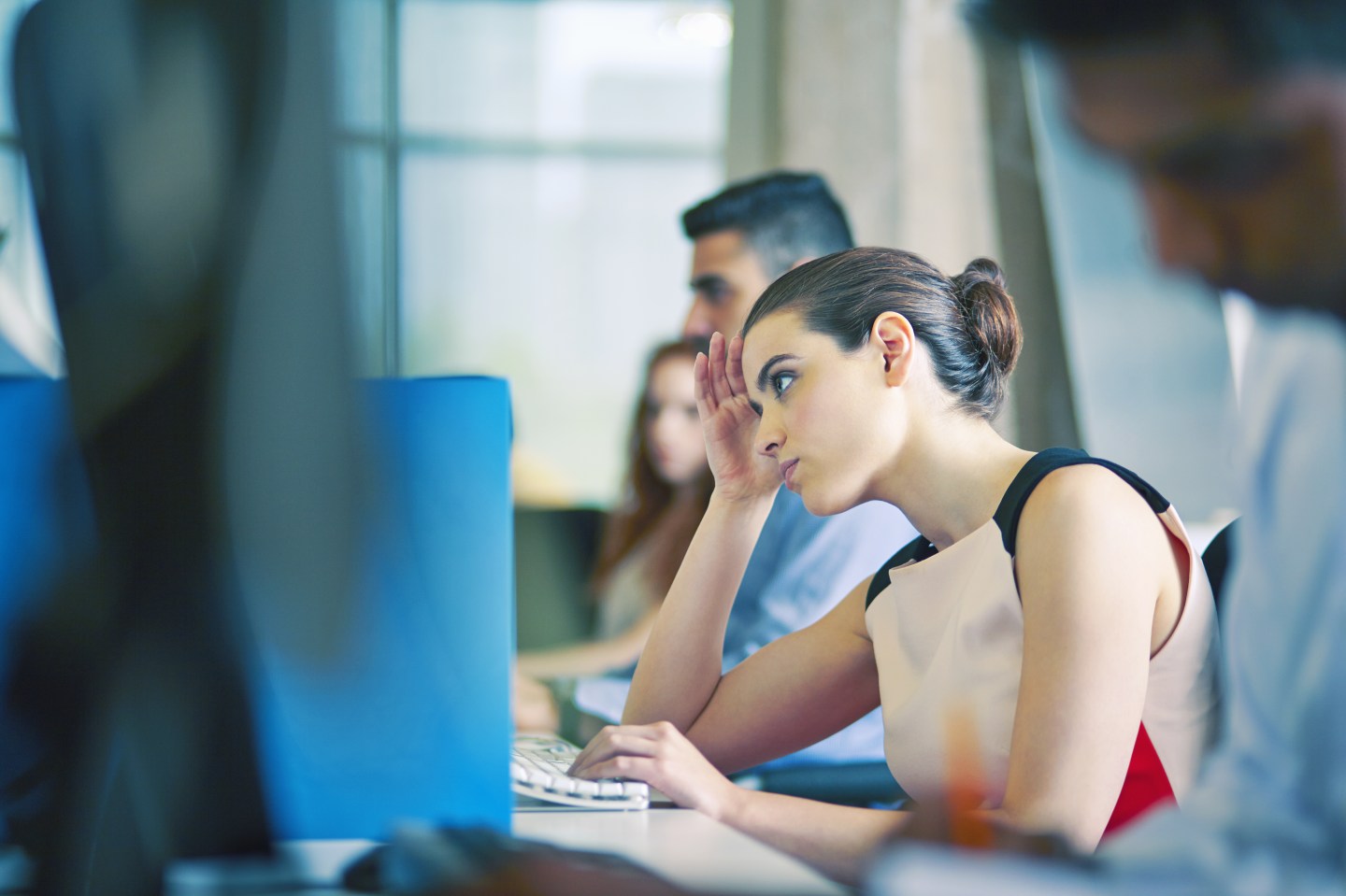 Woman at desk, staring at computer screen
