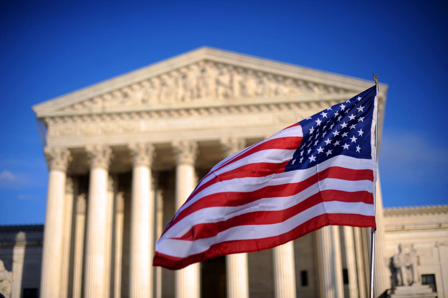 A US flag is held by a marcher in front