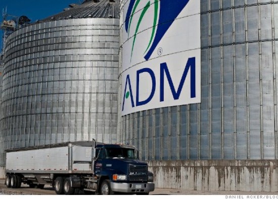 A grain truck passes an Archer Daniels Midland Co. (ADM) logo on the side of a grain storage bin at an ADM grain elevator in Niantic, Illinois, U.S., on Tuesday, Nov. 12, 2013. Photographer: Daniel Acker/Bloomberg
