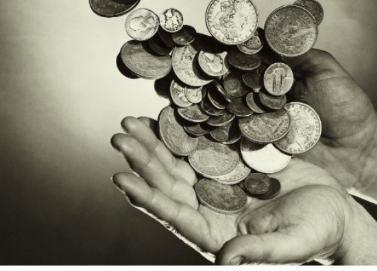 Close-up of coins falling on a person's hands