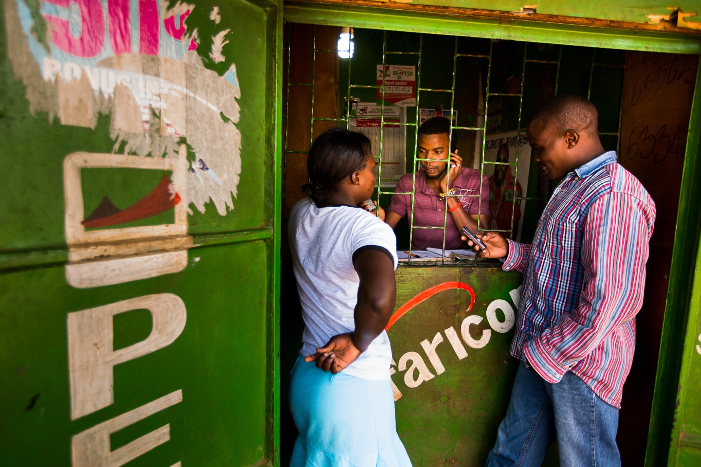 Residents transfer money using the M-Pesa banking service at a store in Nairobi, Kenya in April 2013.