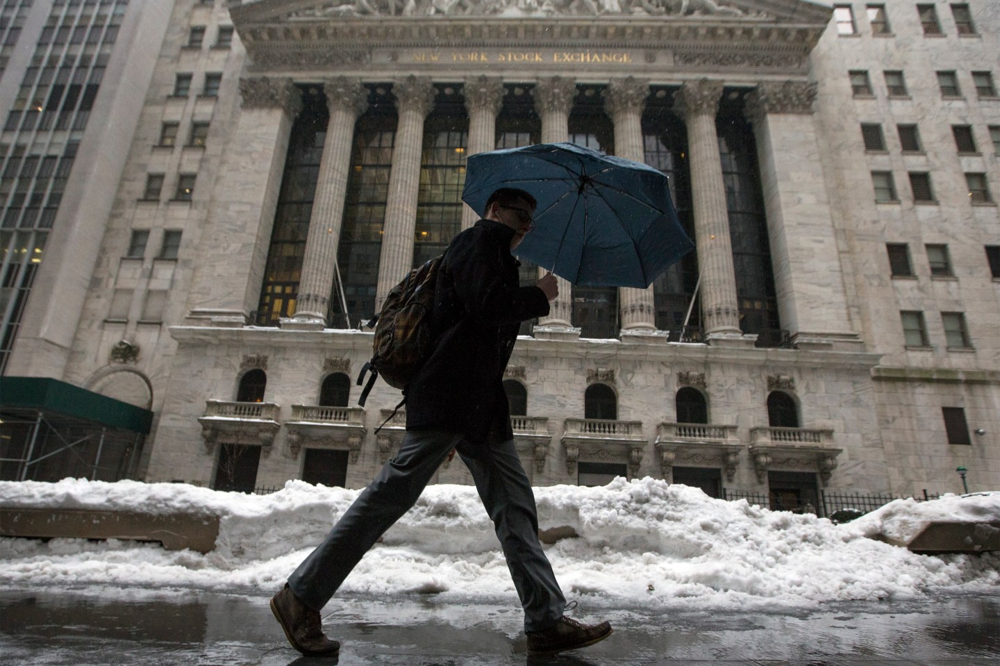 A man walks past the New York Stock Exchange in New York's financial district