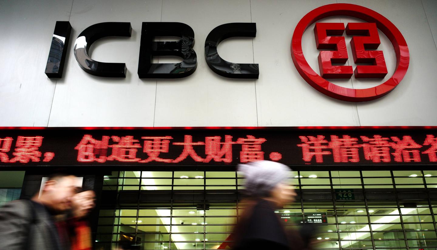 Pedestrians walk past a branch of China'