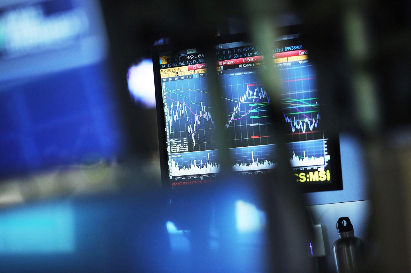 A monitor displays market graphics.