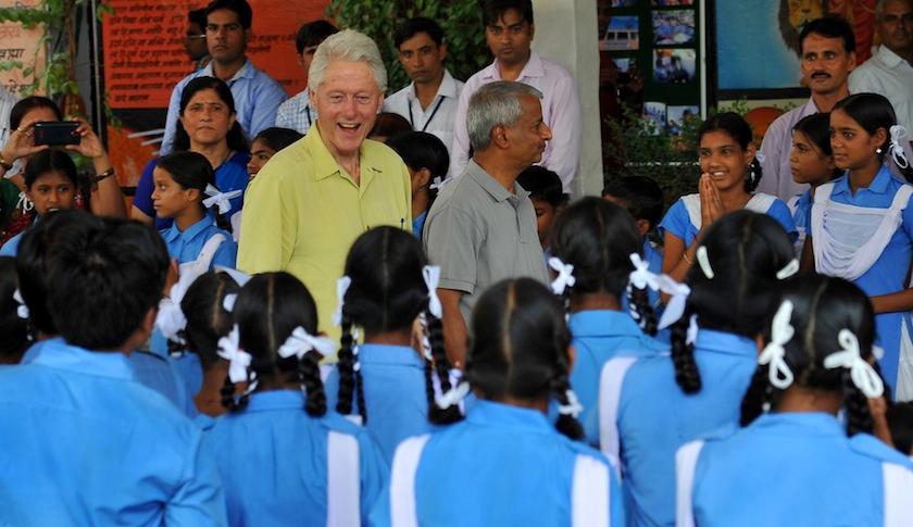 Bill Clinton speaks with schoolchildren during a visit to Sanganer, India