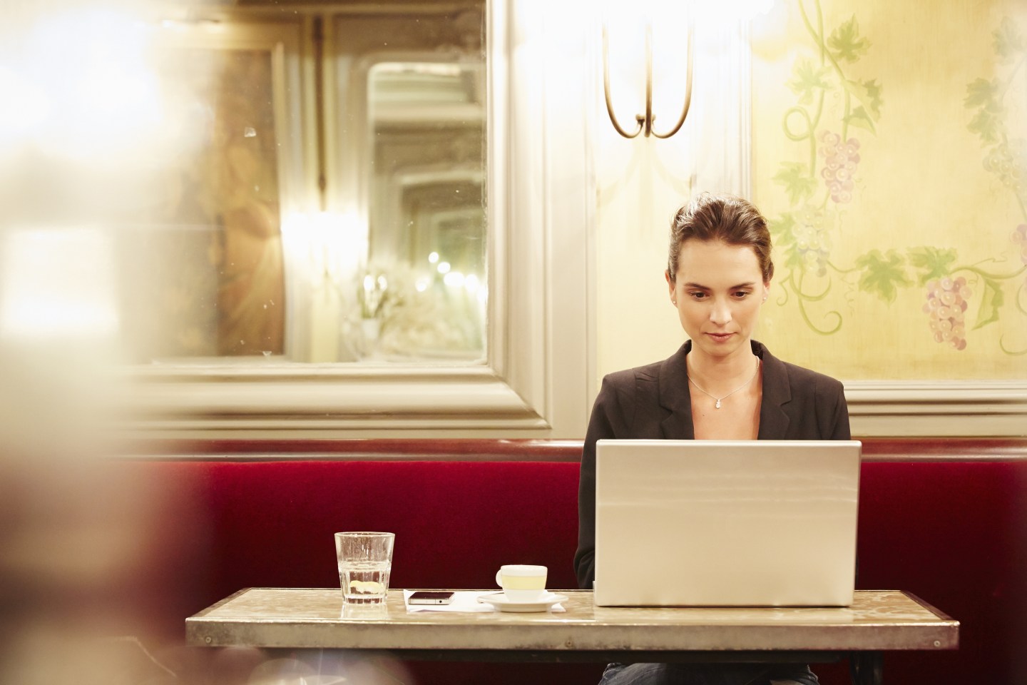Young businesswoman working on laptop in cafe