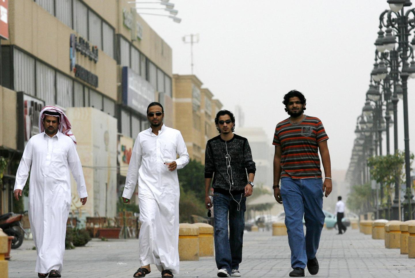 Saudi youths walk together in a business