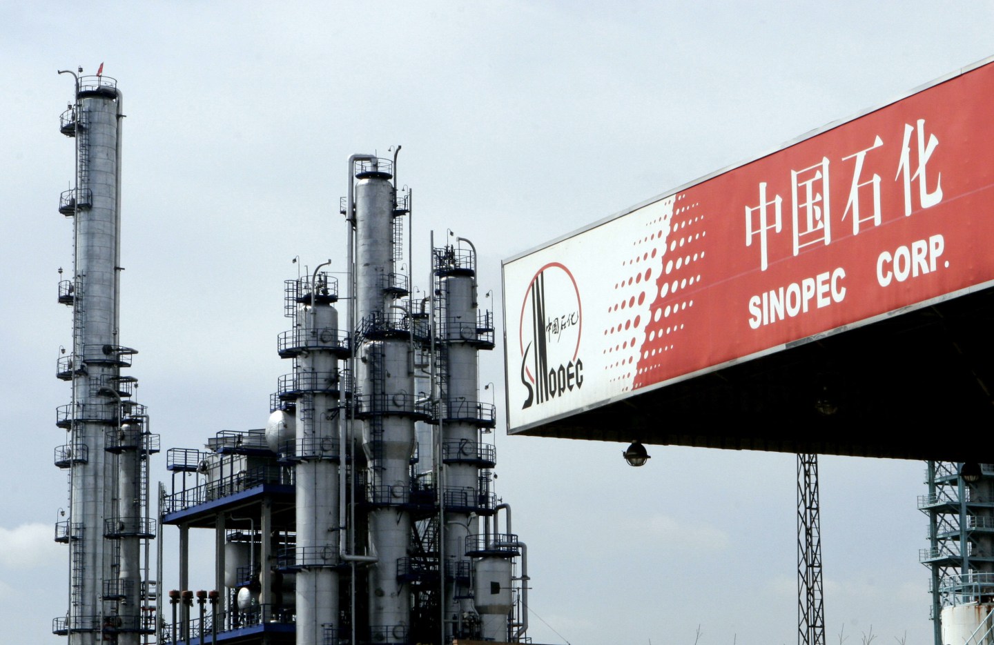 A Sinopec gas station stands in front of a Sinopec oil refin