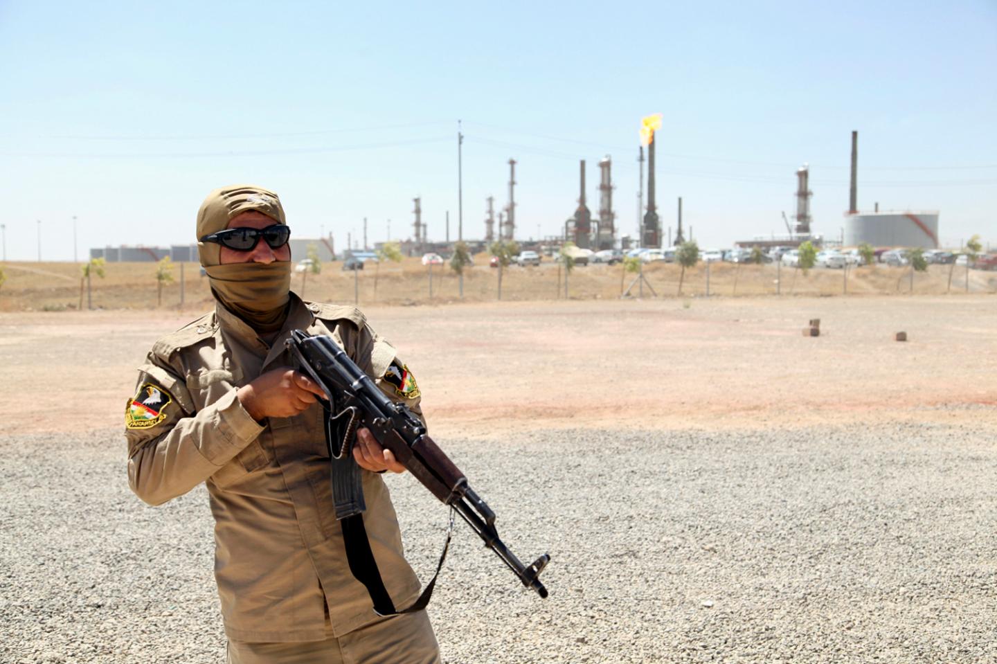 A member of the Kurdish security forces guards an oil refinery on the outskirts of Mosul, Iraq, in June 2014.