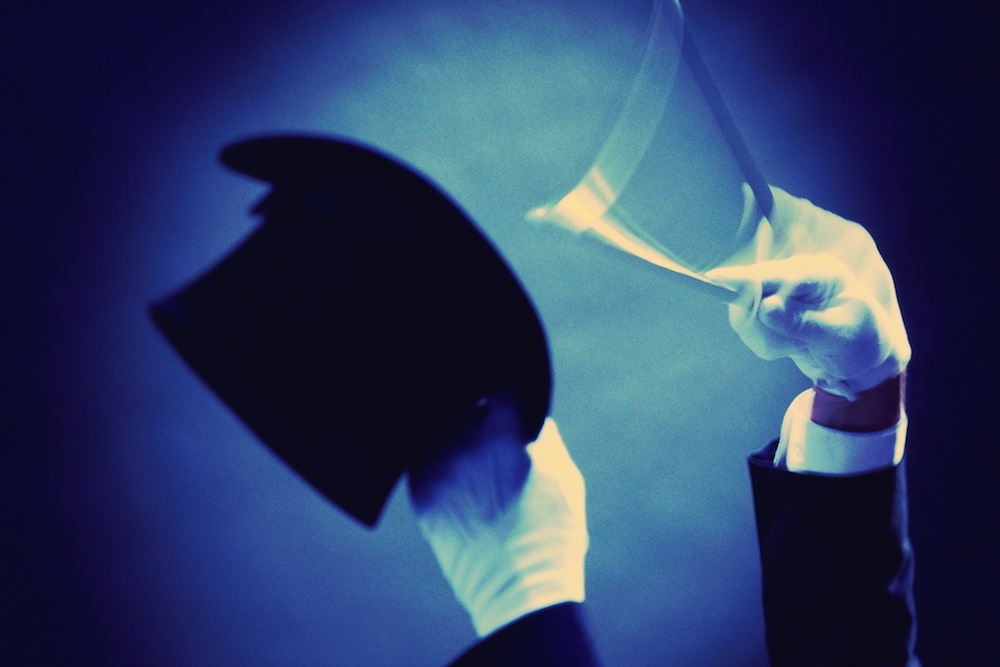 Magician's hands in white gloves
