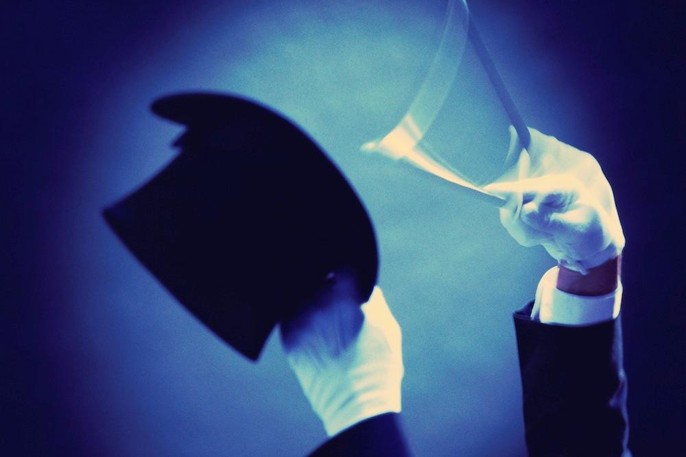 Magician's hands in white gloves