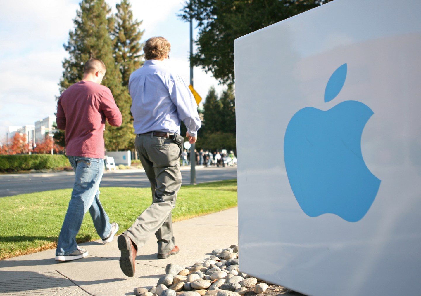 Apple employees walk towards the Apple H