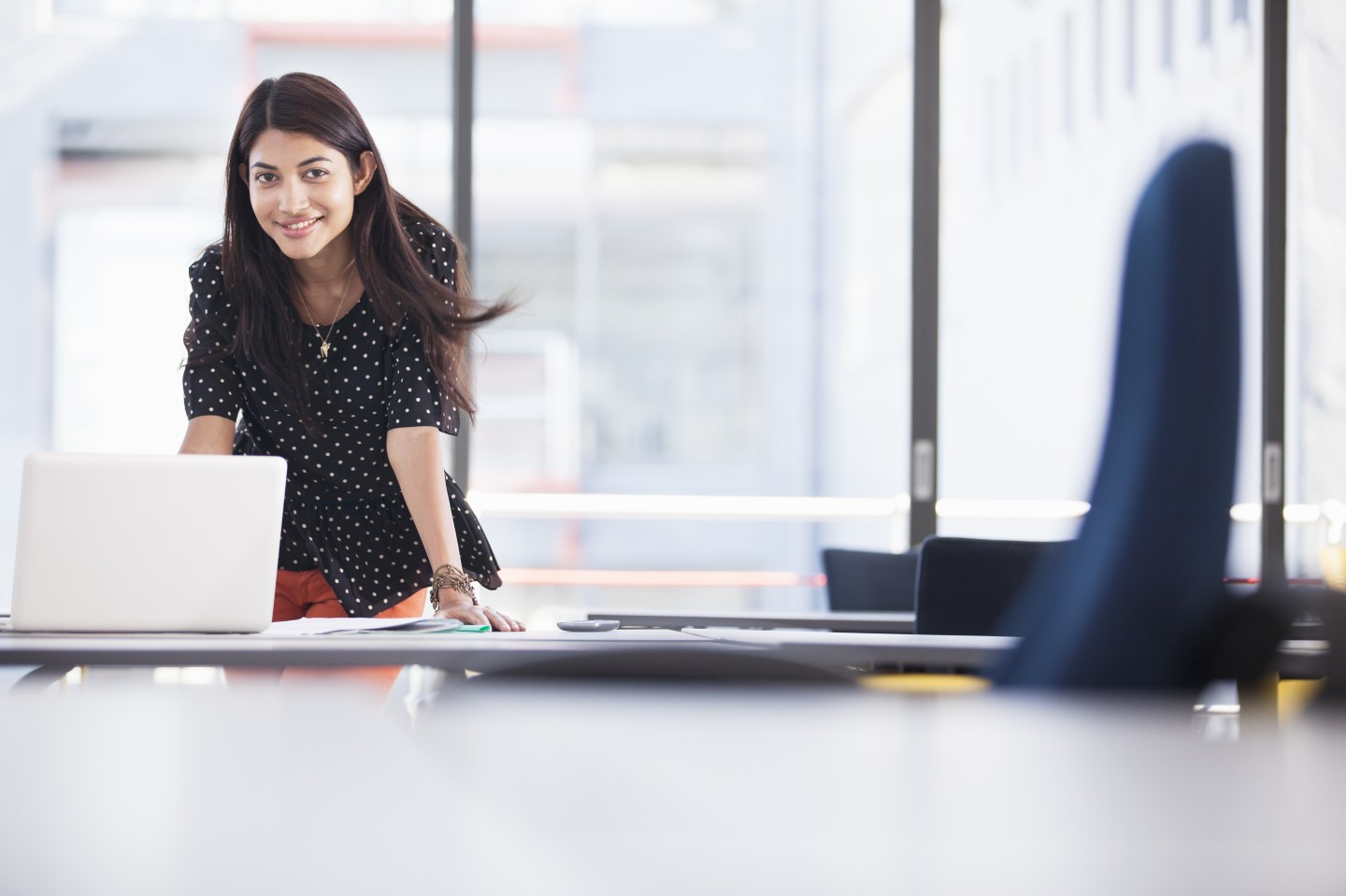 Businesswoman using laptop in modern office