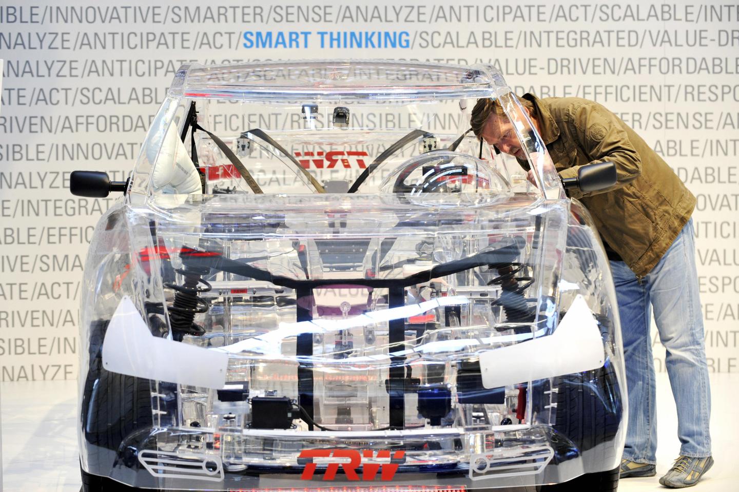 A trade fair visitor looks at a car with