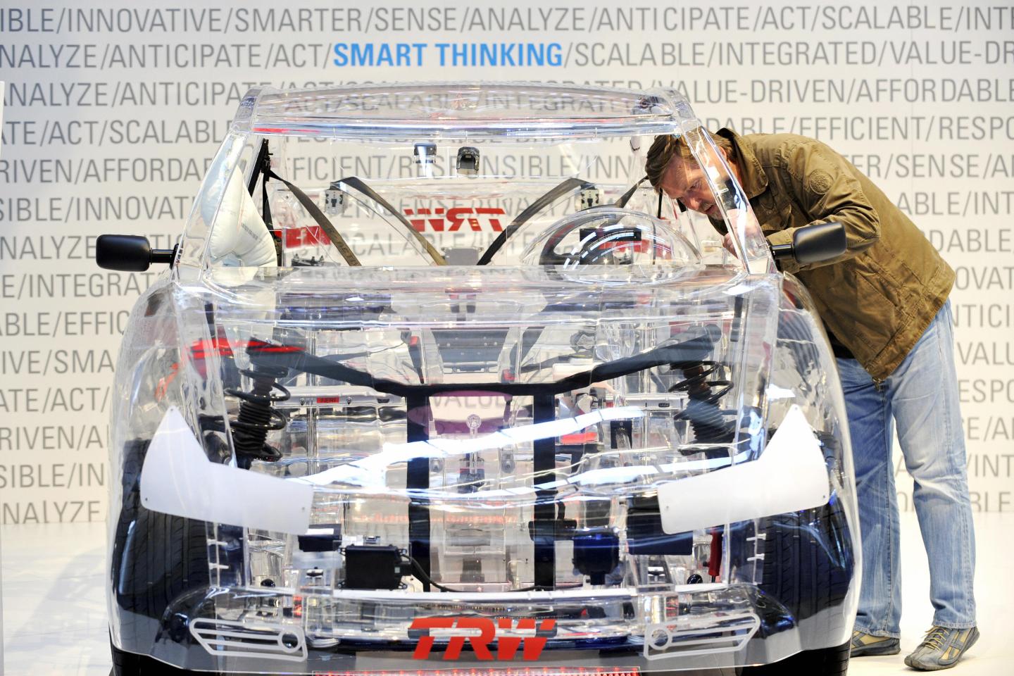 A trade fair visitor looks at a car with