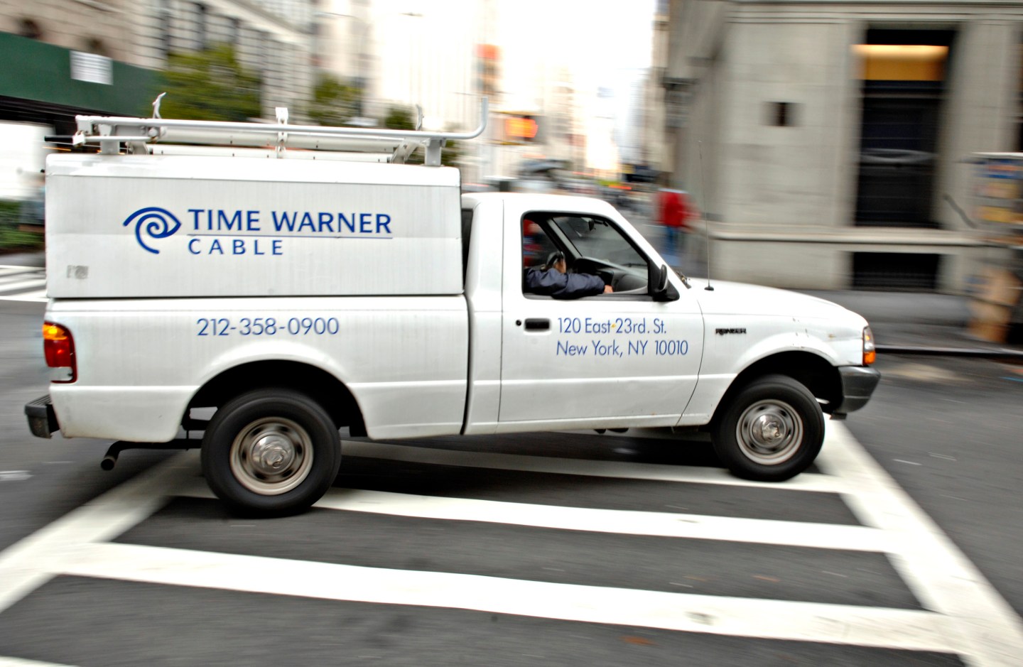A Time Warner Cable trucks turns a corner on a New York stre