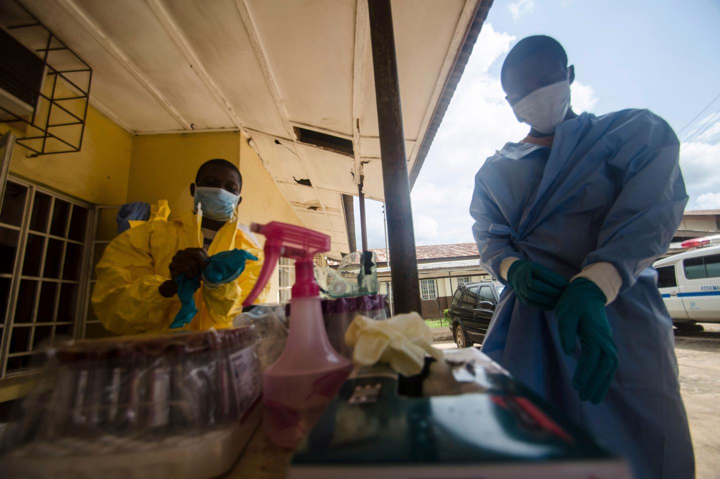 Medical staff put on protective gear in Kenema government hospital before taking a sample from a suspected Ebola patient in Kenema
