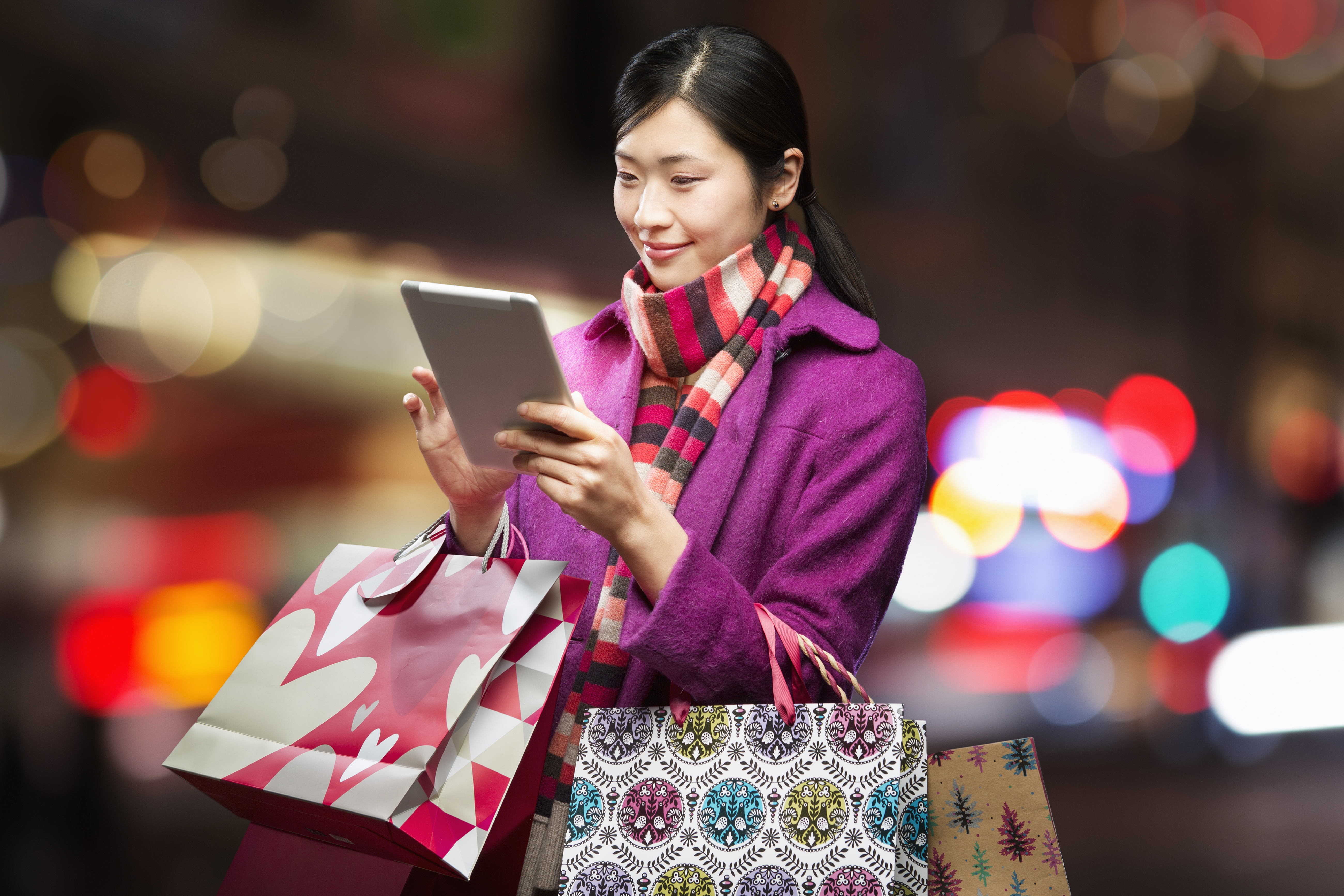 Woman checking wireless device in city,