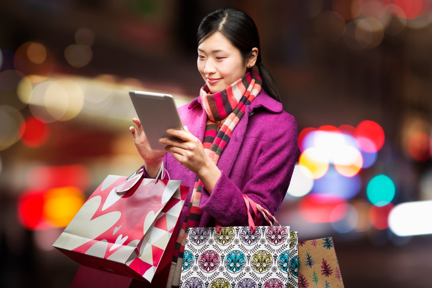 Woman checking wireless device in city,