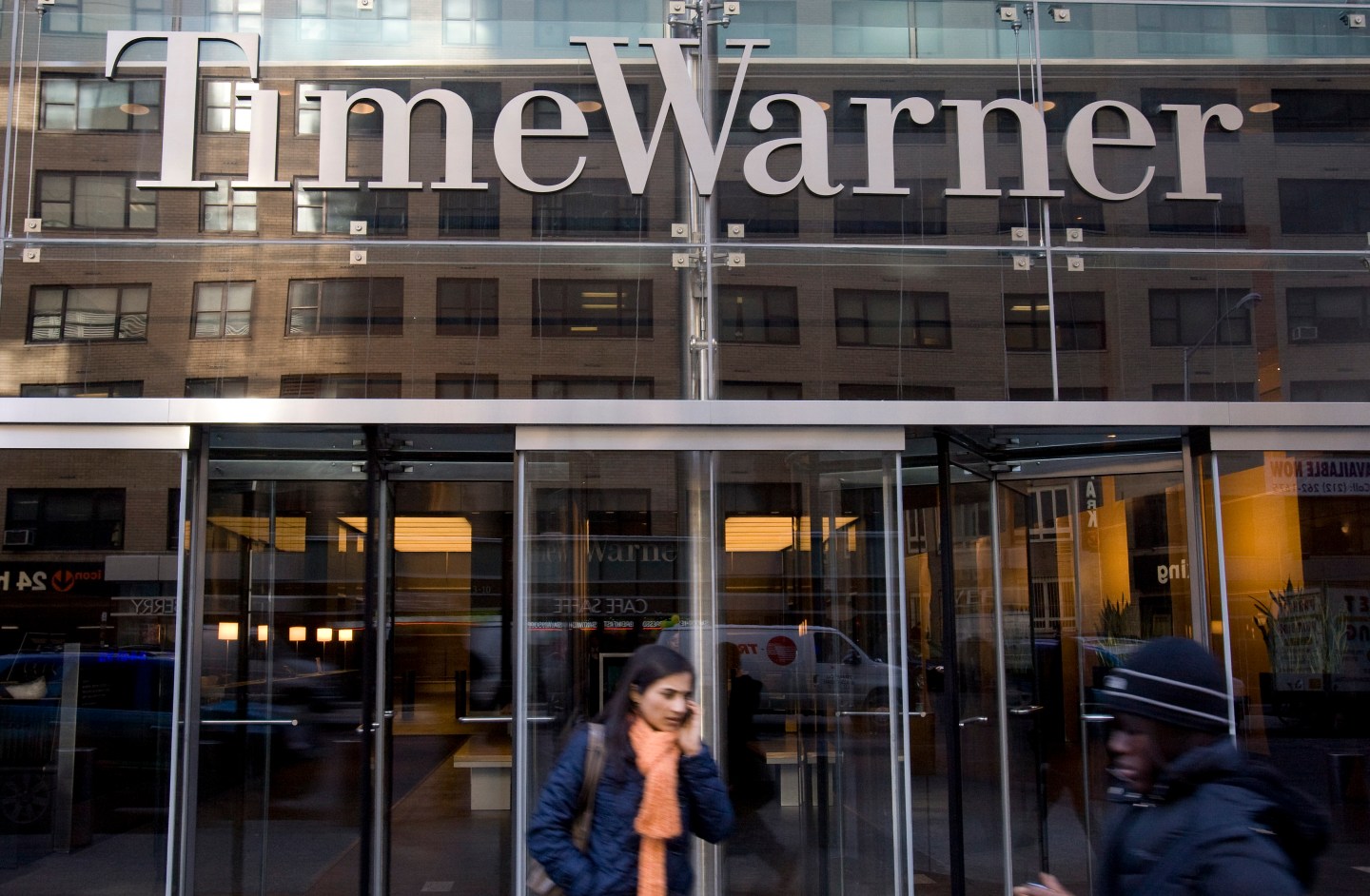 Pedestrians walk past the headquarters of Time Warner Inc. i
