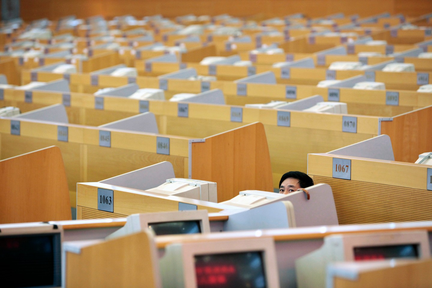A man looks at an electronic board at the Shanghai Stock Exchange in Lujiazui Financial Area in Shanghai