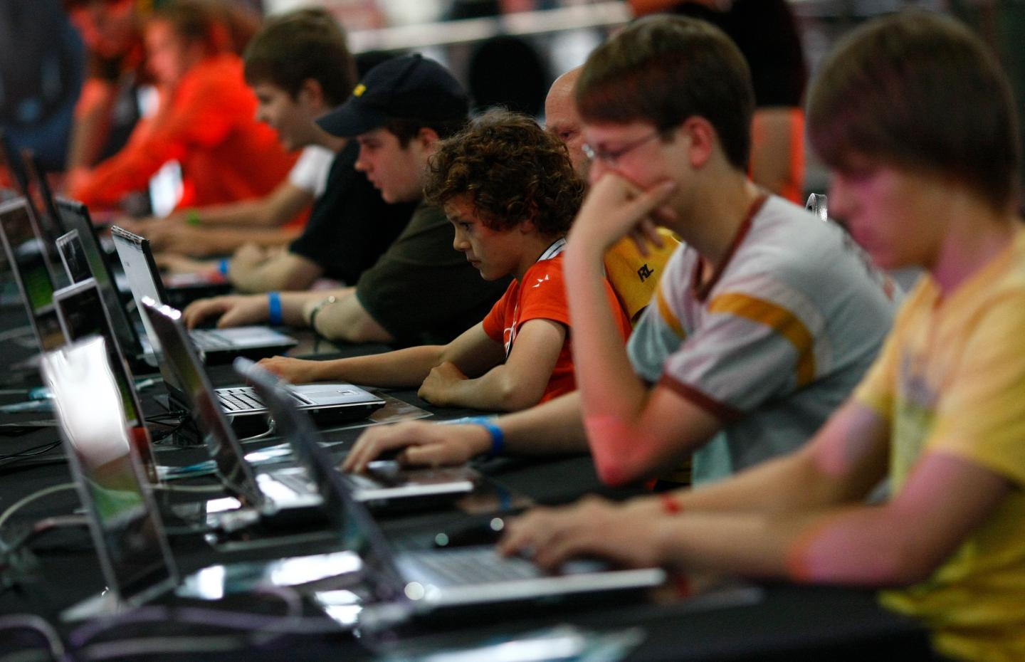 Visitors play at an exhibition stand at the Games Convention Online 2009 fair in Leipzig