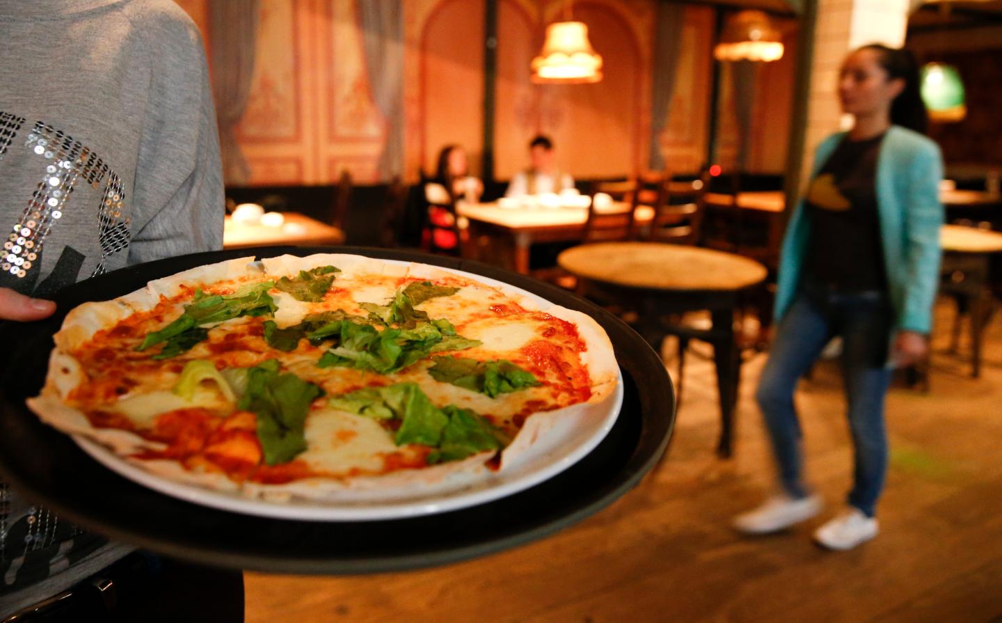 A waitress serves pizza at a restaurant in Moscow