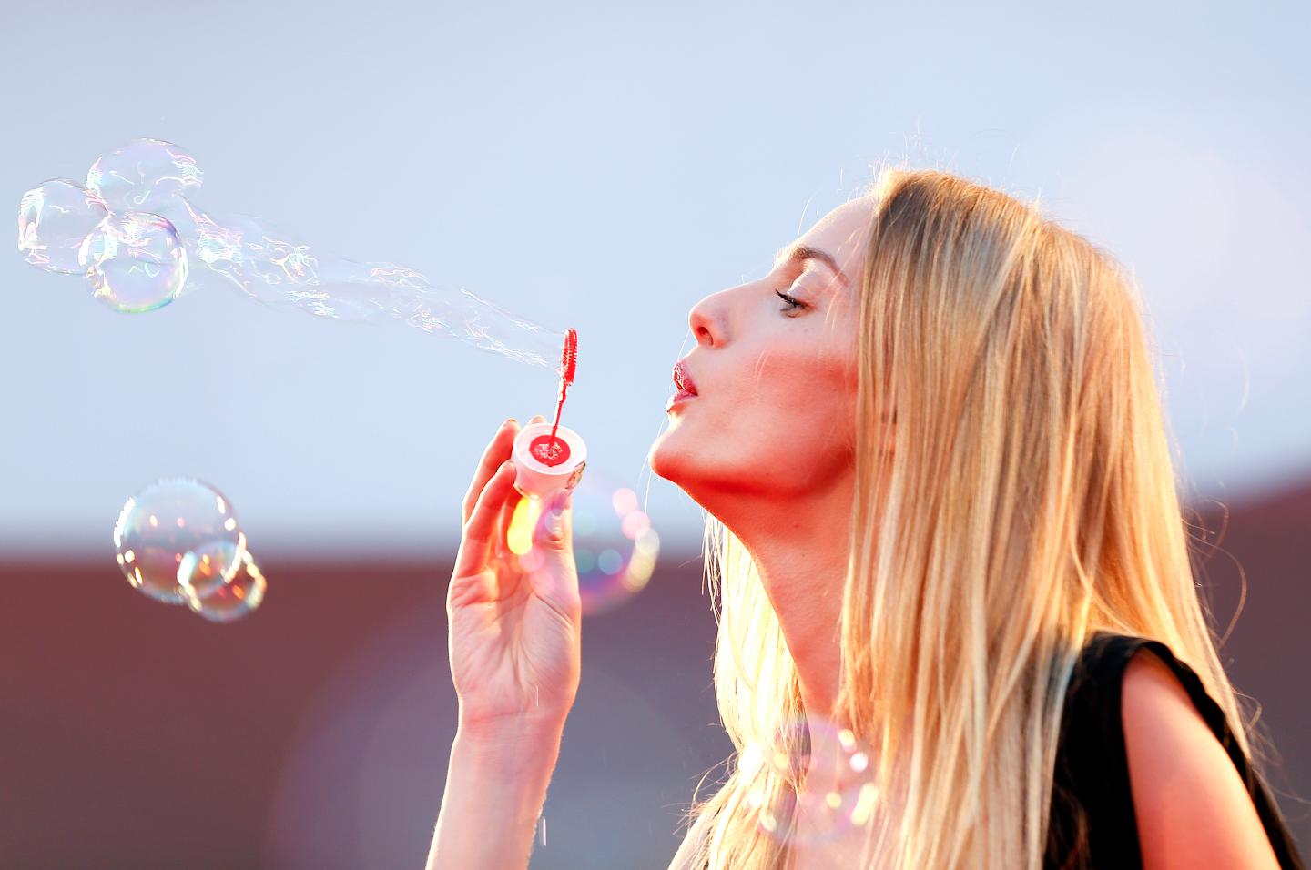Riccobono, actress and model, blows soap bubbles during a red carpet at the 70th Venice Film Festival in Venice
