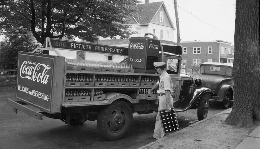 A delivery man unloading cases of Coca-Cola from a truck, circa 1936