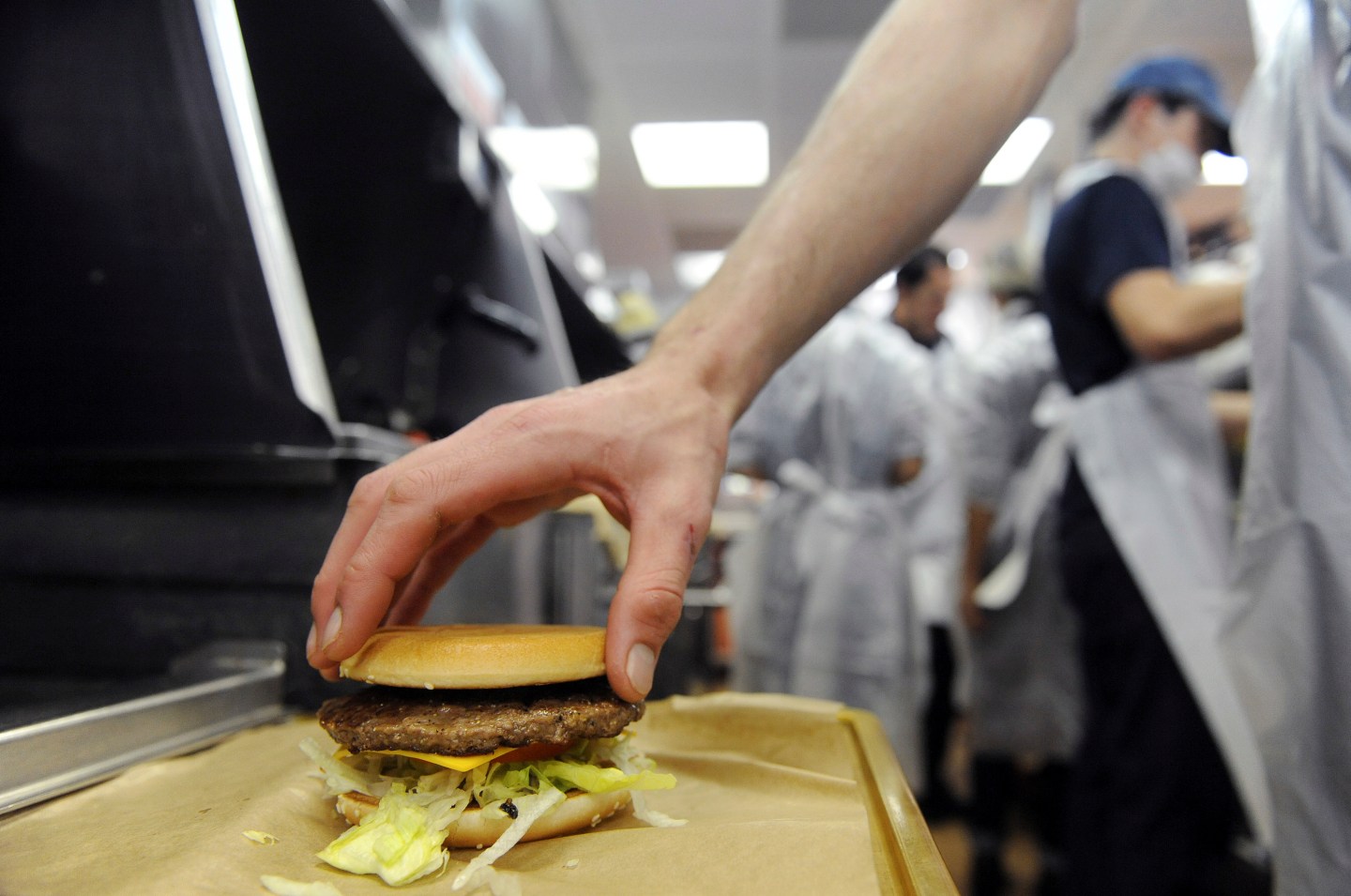 An employee prepares a hamburger at a US