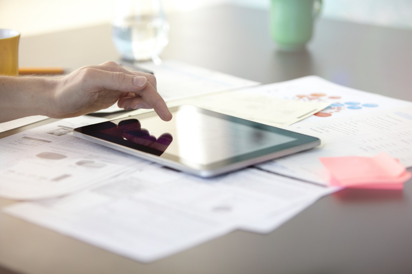 Man using a digital tablet on his desk.