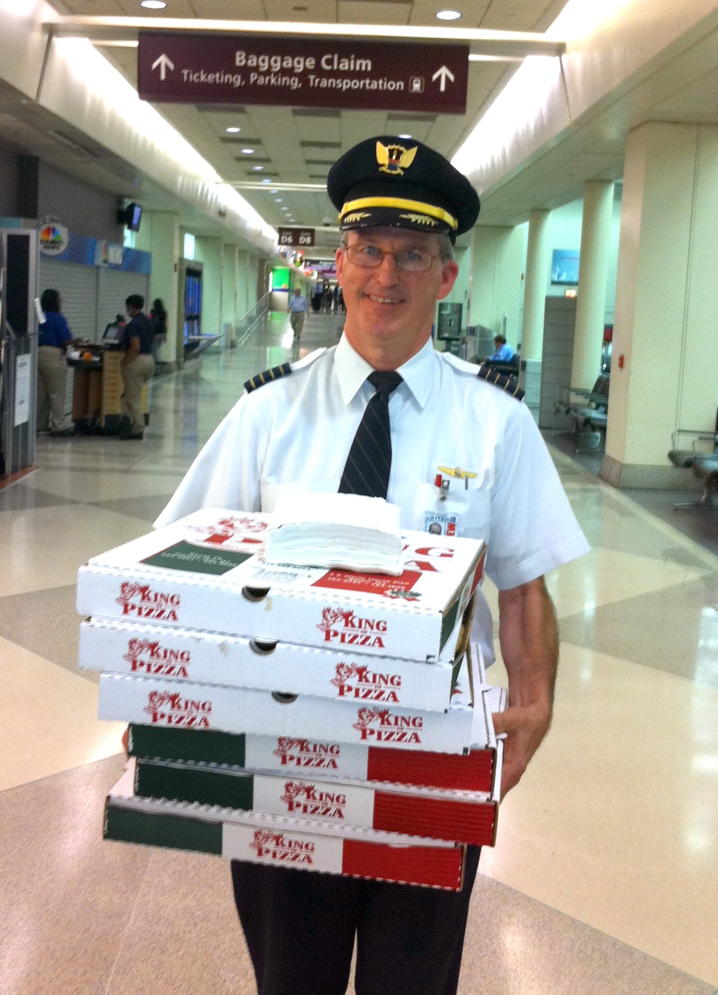 Capt. Denny Flanagan delivers pizza to delayed passengers in Philadelphia in December 2013. Photo courtesy of United Airlines.