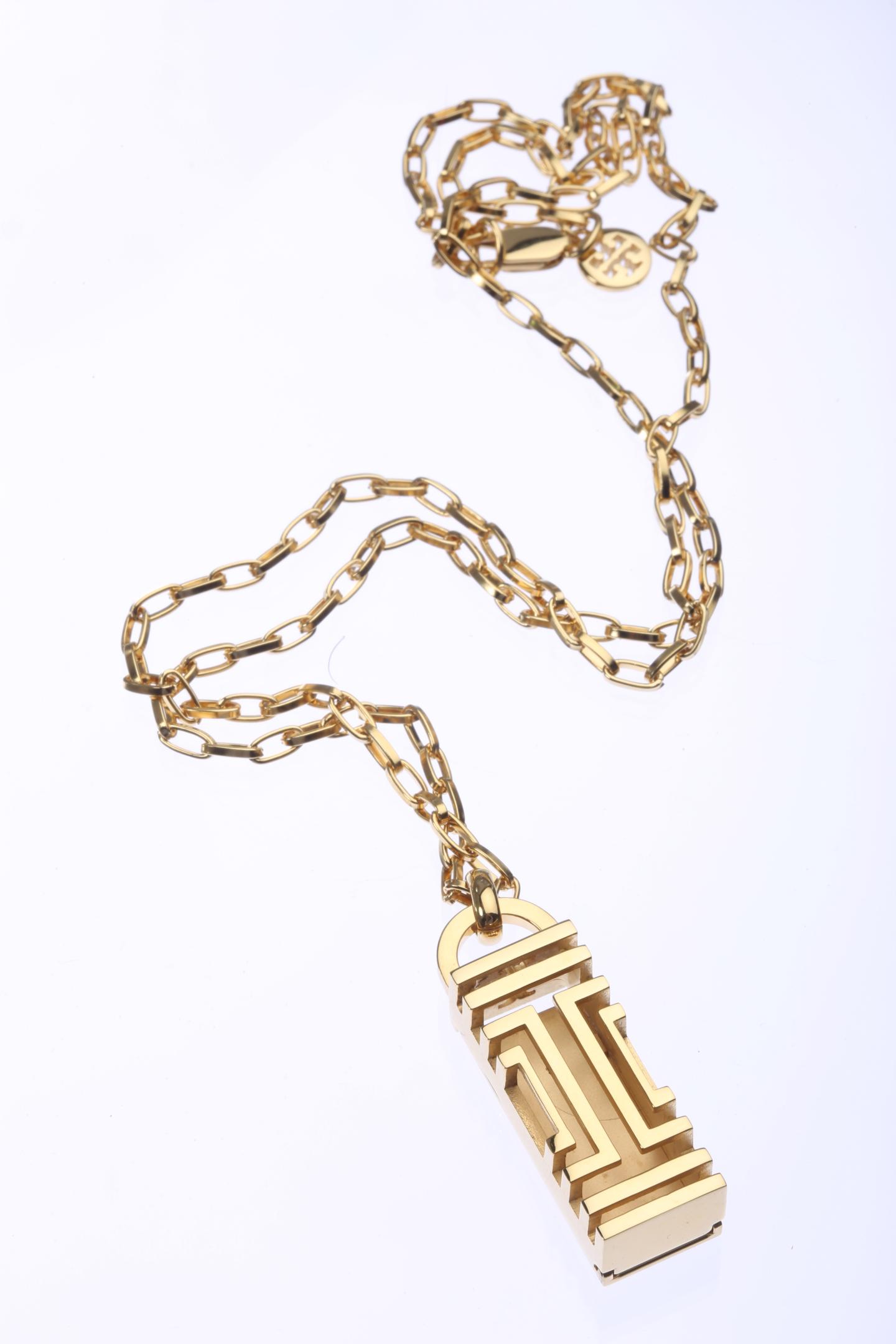 A Fit Bit necklace in gold from Tory Burch.
