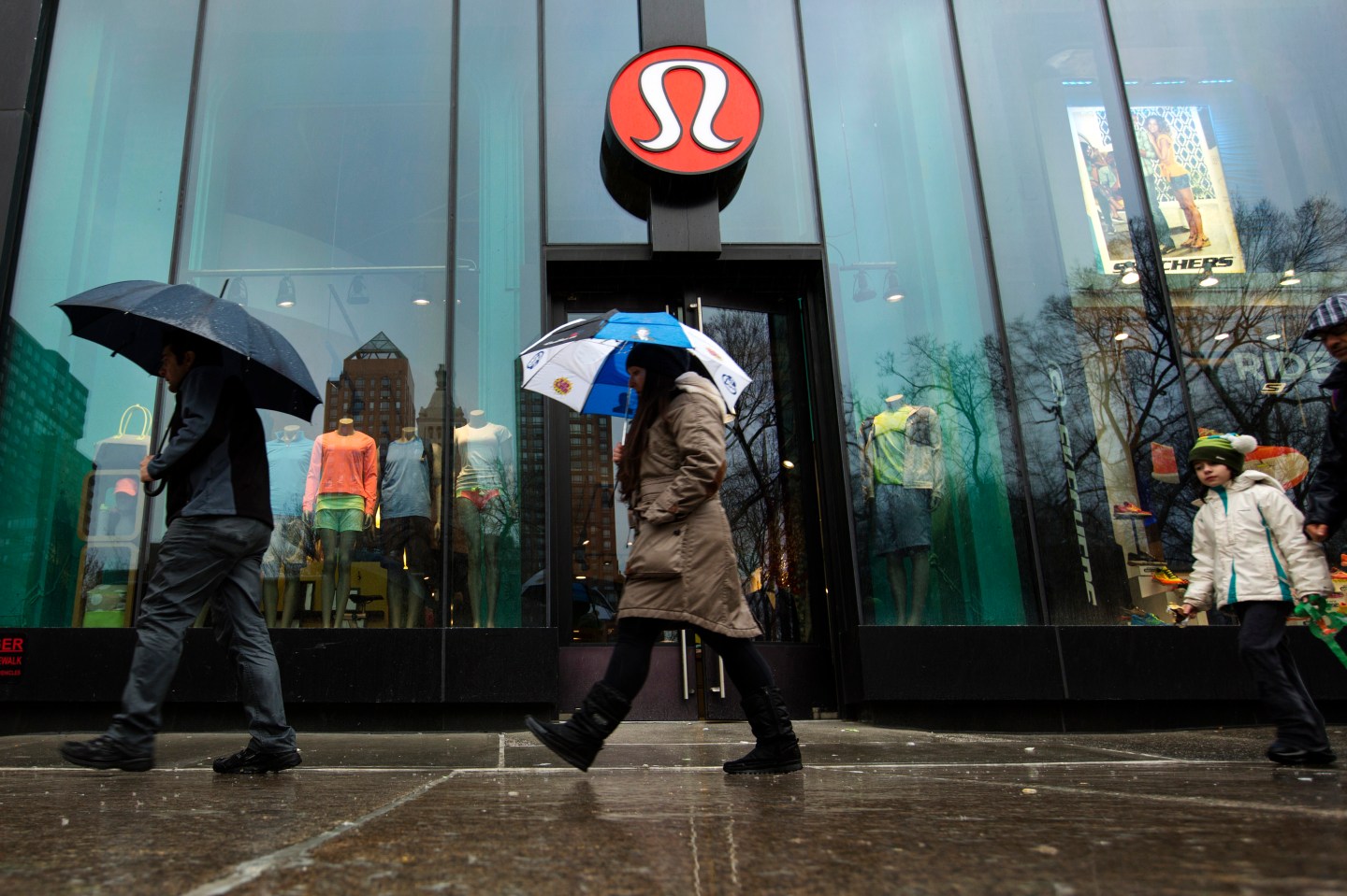Pedestrians walk past a Lululemon Athletica store in New York