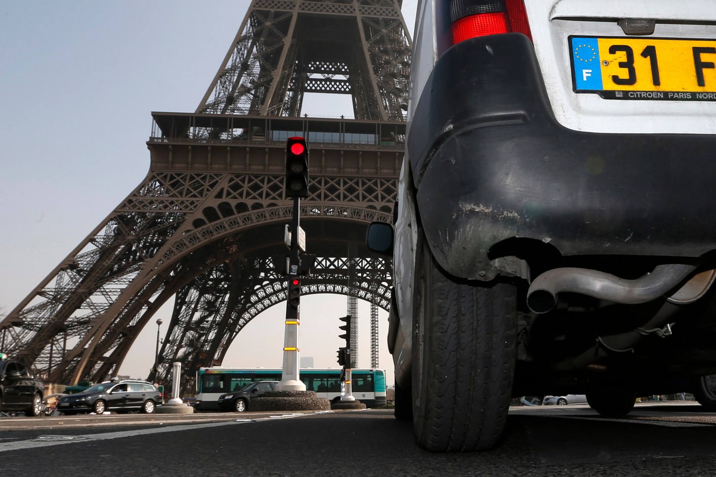 A car drives near the Eiffel tower in Paris during unusually high levels of pollution in France