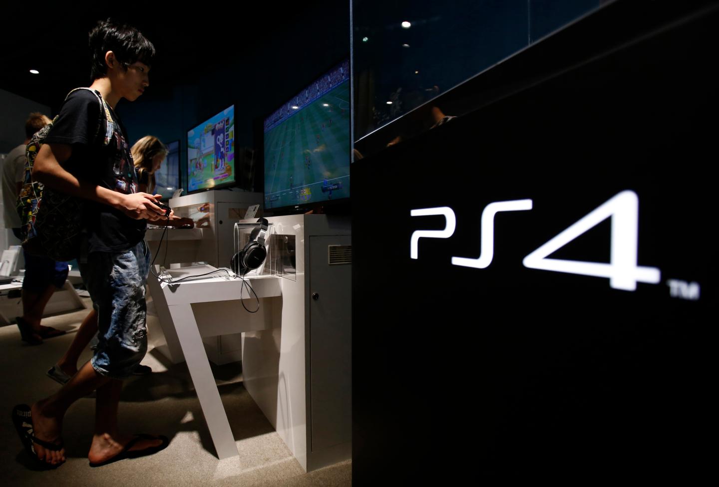 A man plays a video game on Sony Corp's Play Station 4 console at its showroom in Tokyo