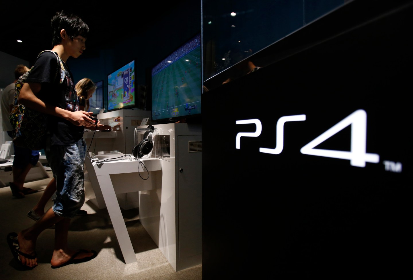 A man plays a video game on Sony Corp's Play Station 4 console at its showroom in Tokyo