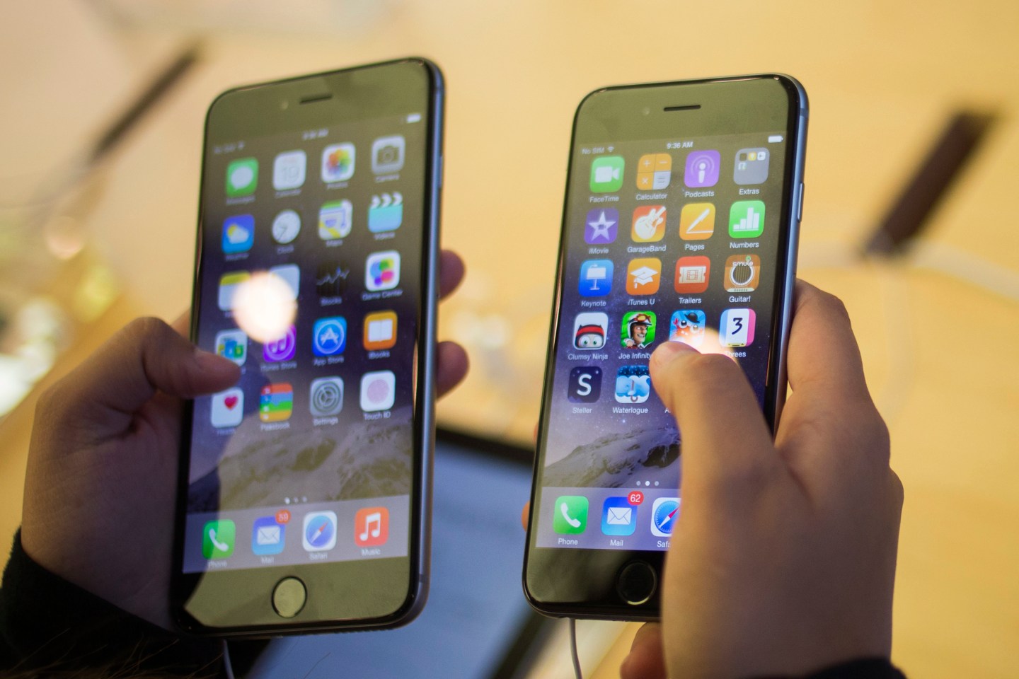 A customer holds an iPhone 6  and iPhone 6 Plus after the phones went on sale at the Fifth Avenue Apple store in Manhattan, New York